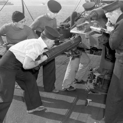 Photographie en noir et blanc – Trois marins s’efforcent de tirer au moyen d’un gros canon.