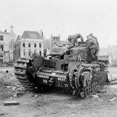 Photographie en noir et blanc – Plusieurs soldats allemands rampent jusqu’à un char d’assaut Churchill abandonné dans un square à Dieppe. L’un des côtés du char a été lourdement endommagé.