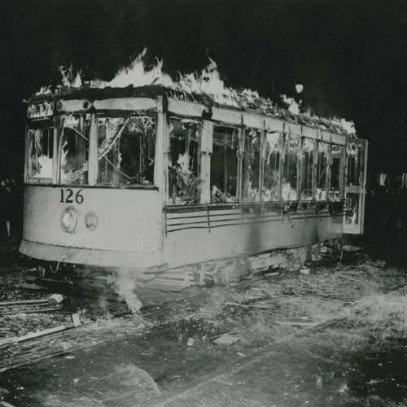 Photographie en noir et blanc – Une voiture de tramway brûle dans la nuit.