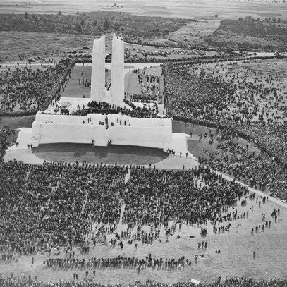 Photographie en noir et blanc – Vue aérienne du monument et de la foule qui l’entoure. L’emblématique sculpture Mère Canada est couverte d’une toile foncée.