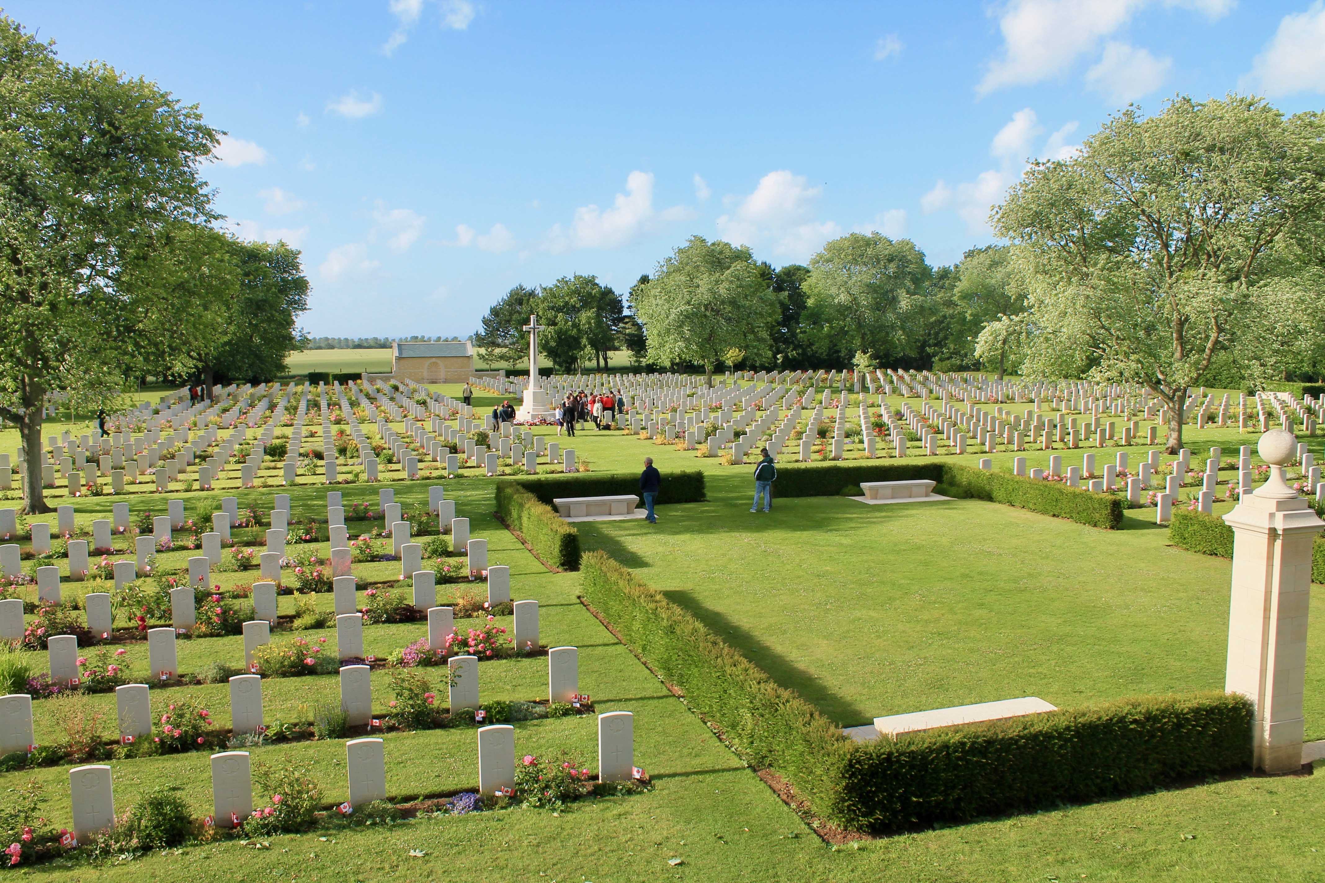 Photographie en couleur – Vue d’un cimetière militaire où se succèdent des rangées uniformes de pierres tombales blanches
