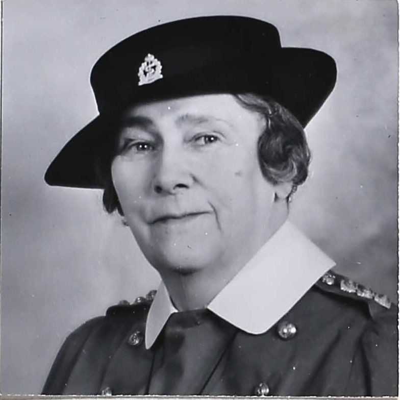Portrait noir et blanc de Nellie dans son uniforme de la Seconde Guerre mondiale. Elle porte un petit chapeau à bord blanc et son col blanc à pointes posé sur sa veste militaire. Des emblèmes sont visibles sur le chapeau et sur ses épaules.